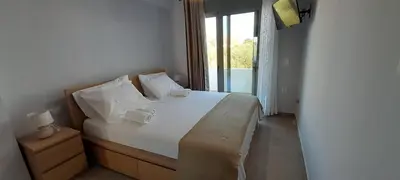 a bedroom with a large white bed with a window at Casa di Laino in Kounoupidhianá