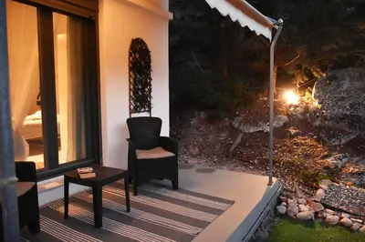 a porch with a chair and a table and a fireplace at Georgia's Dream House in Koprána