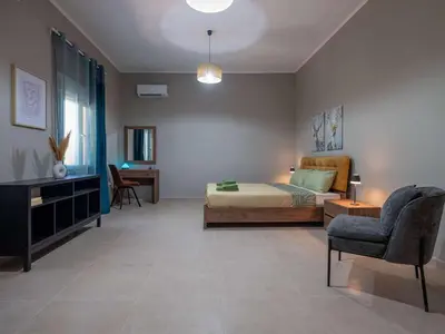 a bedroom with a bed and a chair at loupagio di mare in Plátanos