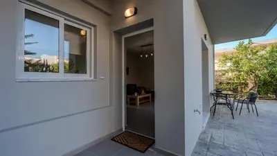 a glass door to a patio with a table and chairs at Heart Of Galatas Apartments Holidays In crete in Galatás
