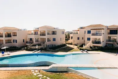 an empty swimming pool in front of some apartment buildings at Phaedrus Living Seaside Thalassa Cretan 101 in Módhion