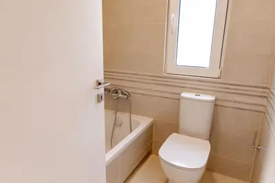 a bathroom with a toilet and a tub and a window at Phaedrus Living Seaside Thalassa Cretan 101 in Módhion