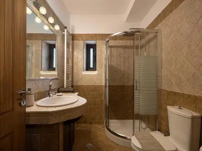 a bathroom with a toilet and a sink and a shower at Villa Staria in Kirtomádhos