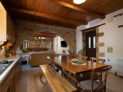 a kitchen and dining room with a wooden table and chairs at Villa Staria in Kirtomádhos