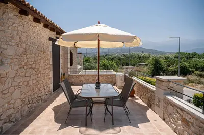 a table and chairs with an umbrella on a patio at Villa Staria in Kirtomádhos
