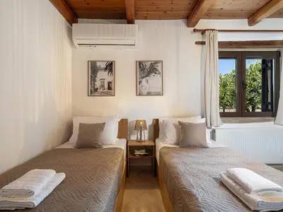 a bedroom with two beds and a window at Villa Staria in Kirtomádhos