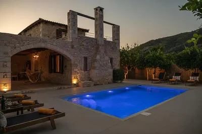 a swimming pool in front of a stone house at Villa Staria in Kirtomádhos