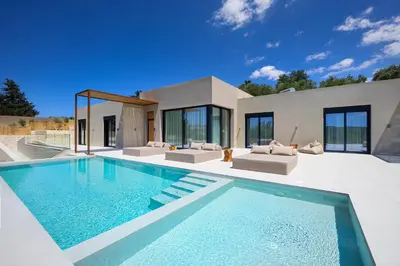 a villa with a swimming pool in front of a house at Elithos Villa in Vryses