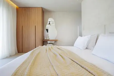 a bedroom with a large white bed with a blanket on it at Elithos Villa in Vryses
