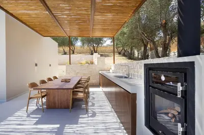 a dining room with a fireplace and a table at Elithos Villa in Vryses