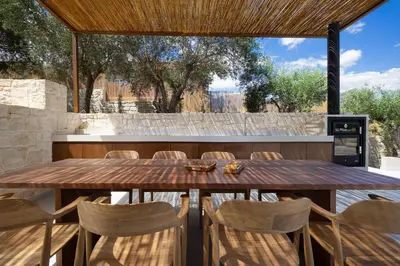 an outdoor dining room with a wooden table and chairs at Elithos Villa in Vryses