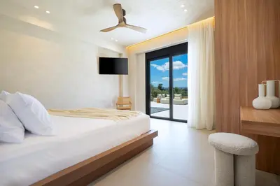 a bedroom with a bed and a large window at Elithos Villa in Vryses