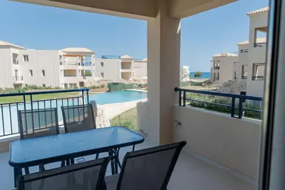 a balcony with a table and chairs and a pool at Phaedrus Living Seaside Thalassa Cretan D101 in Módhion