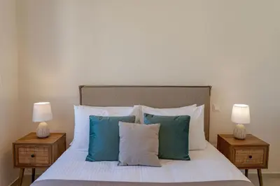 a bedroom with a bed with blue pillows and two lamps at Phaedrus Living Seaside Thalassa Cretan D101 in Módhion