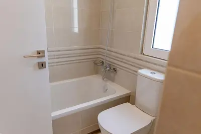 a bathroom with a toilet and a tub and a sink at Phaedrus Living Seaside Thalassa Cretan D101 in Módhion