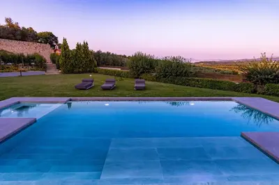 a swimming pool in a yard with two lounge chairs at Villa Aurora 1- Getaway Bliss in Xamoudhokhórion