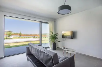 a living room with a couch and a large window at Villa Aurora 1- Getaway Bliss in Xamoudhokhórion