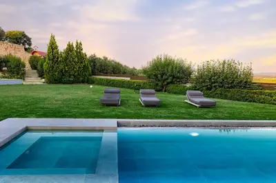 a swimming pool in a yard with two lounge chairs at Villa Aurora 1- Getaway Bliss in Xamoudhokhórion