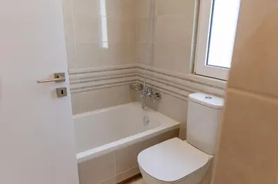 a bathroom with a toilet and a tub and a sink at Phaedrus Living Seaside Thalassa Cretan 102 in Módhion