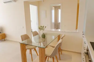 a glass dining room table with chairs and a mirror at Phaedrus Living Seaside Thalassa Cretan 102 in Módhion