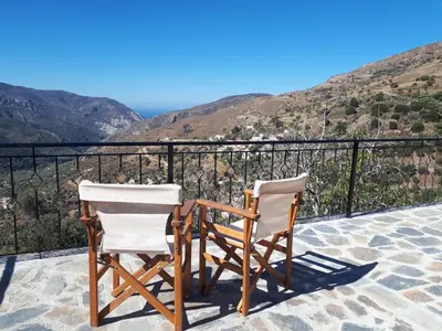 two chairs sitting on a balcony with a view at Panorama Apartment in Kefálion