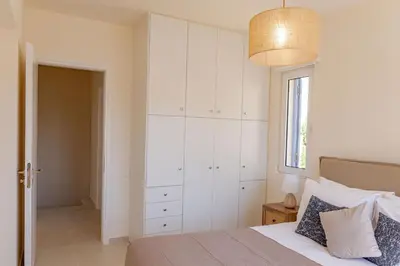 a bedroom with a bed and a large white cabinet at Phaedrus Living Seaside Thalassa Cretan 103 in Módhion