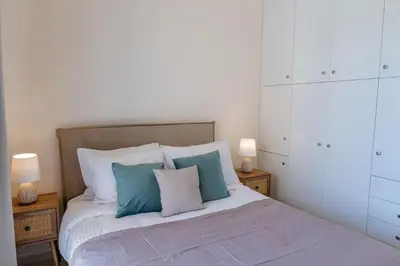 a bedroom with a bed with blue and white pillows at Phaedrus Living Seaside Thalassa Cretan 201 in Módhion