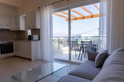 a living room with a couch and a kitchen with a balcony at Phaedrus Living Seaside Thalassa Cretan 201 in Módhion