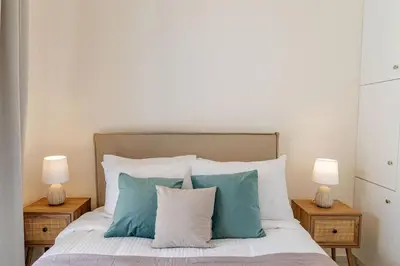 a bedroom with a bed with pillows and two lamps at Phaedrus Living Seaside Thalassa Cretan 201 in Módhion