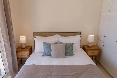 a bedroom with a bed with pillows and two lamps at Phaedrus Living Seaside Thalassa Cretan 202 in Módhion