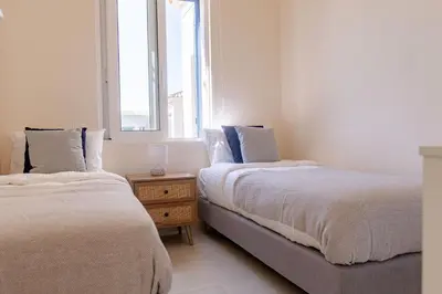 two beds in a room with a window at Phaedrus Living Seaside Thalassa Cretan 202 in Módhion