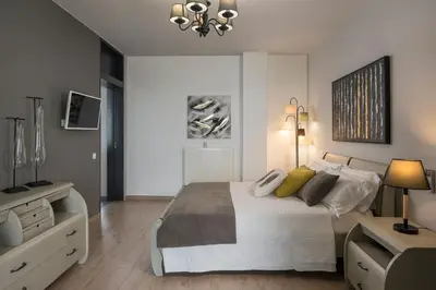 a bedroom with a bed and a dresser and a television at Luxury Villa Olivenest with Private Heated Pool, Hot Tub & Sauna in Chania Town