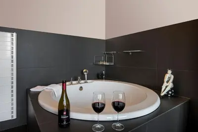 a bath tub with two bottles and two glasses of wine at Luxury Villa Olivenest with Private Heated Pool, Hot Tub & Sauna in Chania Town
