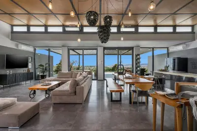 a living room with a couch and tables and windows at Luxury Villa Olivenest with Private Heated Pool, Hot Tub & Sauna in Chania Town