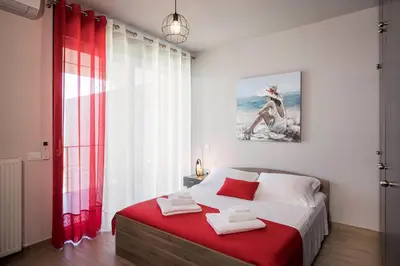 a bedroom with a bed with a red blanket at Luxury Villa Olivenest with Private Heated Pool, Hot Tub & Sauna in Chania Town