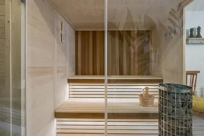 a sauna with a wooden floor and a glass wall at Luxury Villa Olivenest with Private Heated Pool, Hot Tub & Sauna in Chania Town