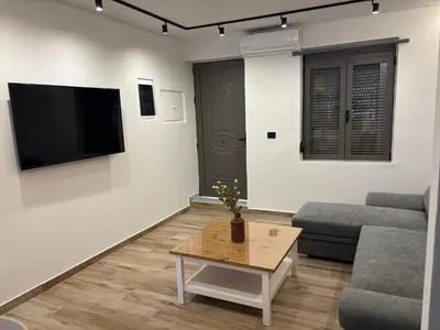 a living room with a couch and a tv on a wall at Sofia's Home in Chania Town