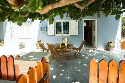 a patio with a table and chairs in front of a house at Arnildi's View in Nopíyia