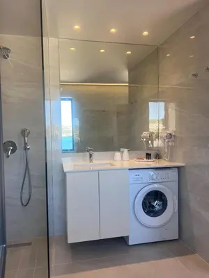a bathroom with a washing machine and a shower at Bay view in town in Chania Town