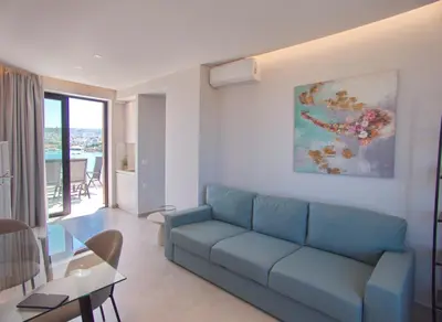 a living room with a blue couch and a table at Bay view in town in Chania Town