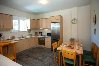 a kitchen with a table and a refrigerator at Pyrgos Spring pool apartment in Maleme