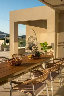 a wooden table with rattan chairs on a patio at Villa Navelina in Mourí
