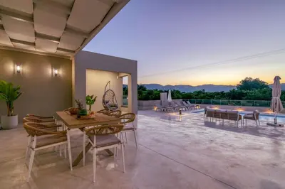 a dining room with a table and chairs on a patio at Villa Navelina in Mourí