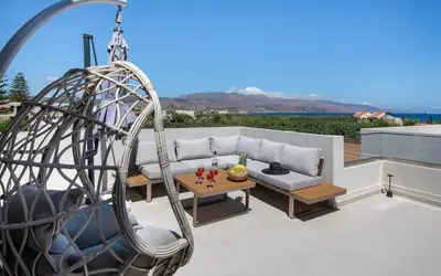 a patio with a couch and a swing at Ethernal Luxury Maisonette-Next to the sea in Kamisianá