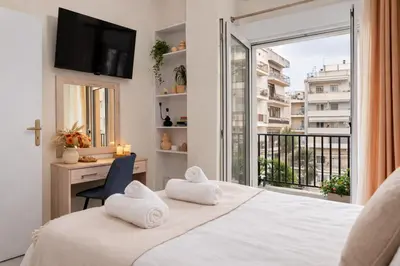 a bedroom with a bed and a large window at Ela Apartment Chania in Chania Town