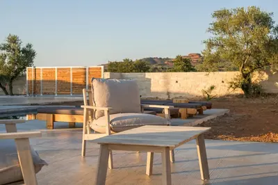 a chair sitting on top of a patio with tables at Villa Zen in Alikianós