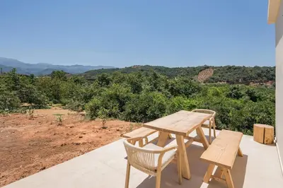 a wooden table and chairs on a patio with a view at Villa Zen in Alikianós