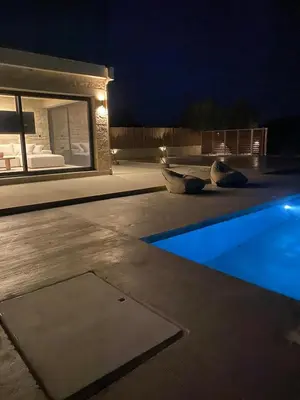a pool at night with two birds sitting next to it at Villa Zen in Alikianós
