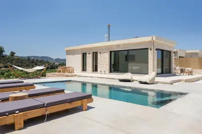 a swimming pool with lounge chairs and a house at Villa Zen in Alikianós