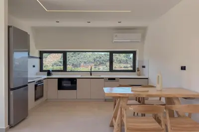a kitchen with a wooden table and a dining room at Villa Kumarēs in Alikianós